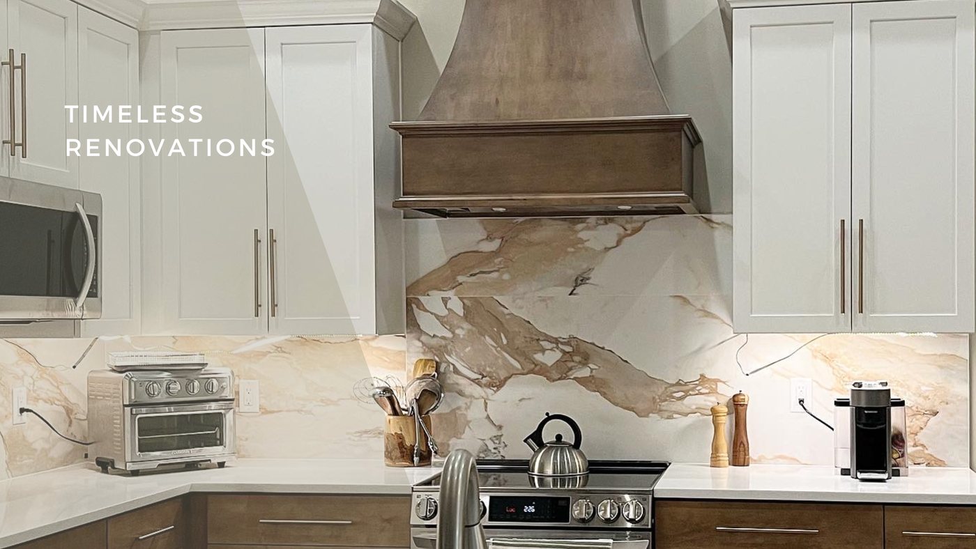 Kitchen with a marble slab backsplash, brass hardware and pale cabinetry
