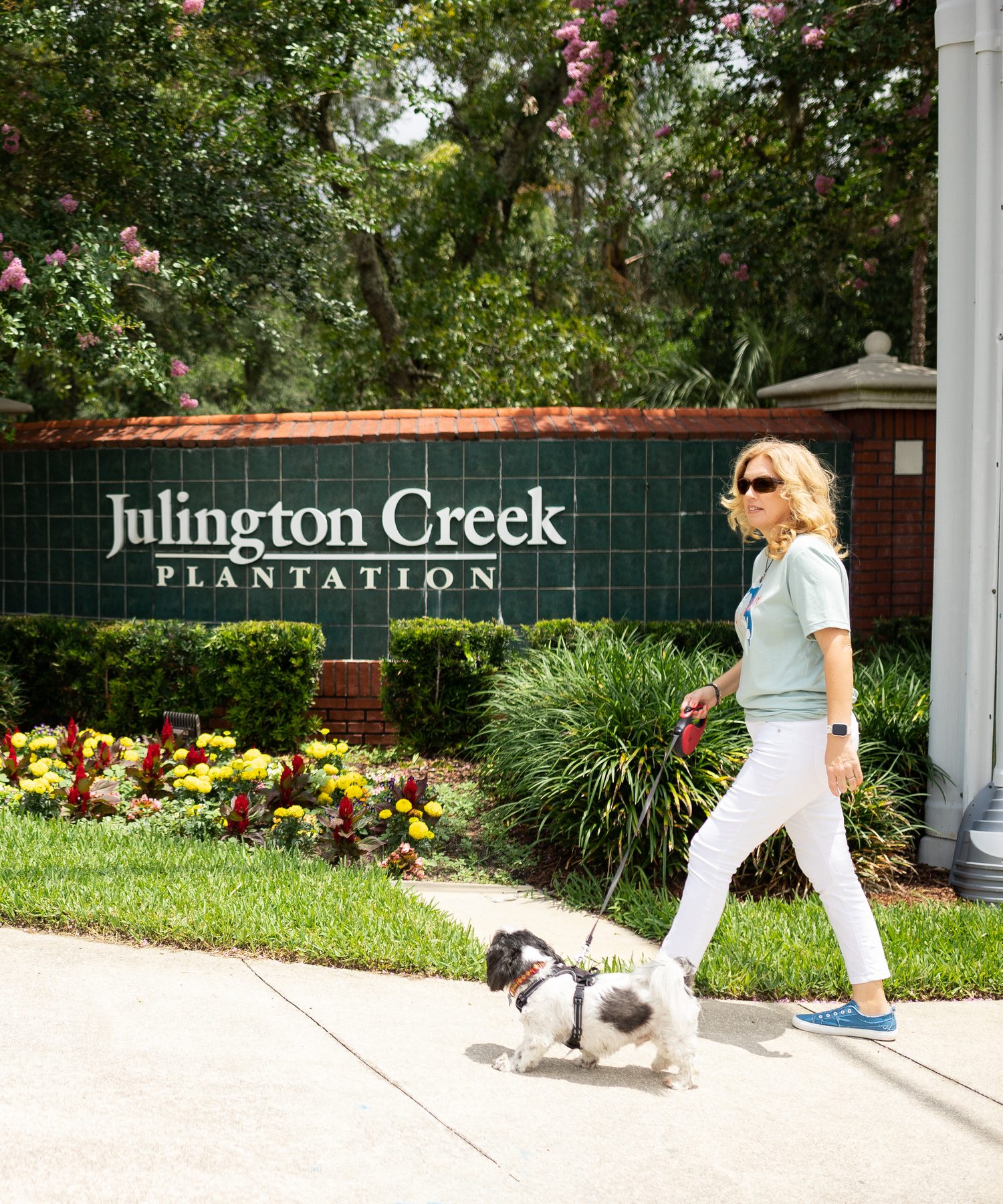 Gina Graham walking her dog past the Julington Creek Plantation sign