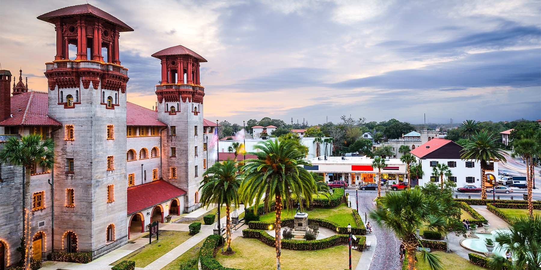 Twin towers and a palm-planted plaza in downtown St. Augustine at dusk